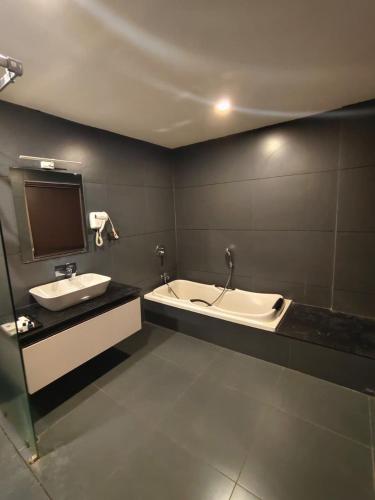 a bathroom with a bath tub and a sink at HOTEL SKY PARADISE in Iritti