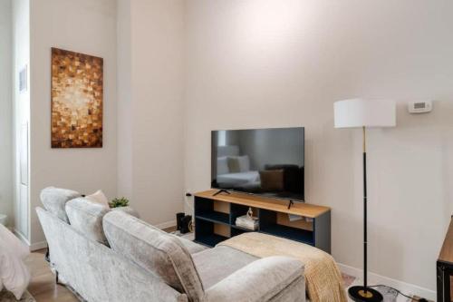 a living room with a couch and a flat screen tv at CBDOTR 24-7 Gym Pool Rooftop Steps to Stadiums in Cincinnati
