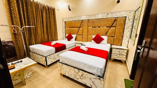 a hotel room with two beds and a shower at New Like Home Hotel in Lahore