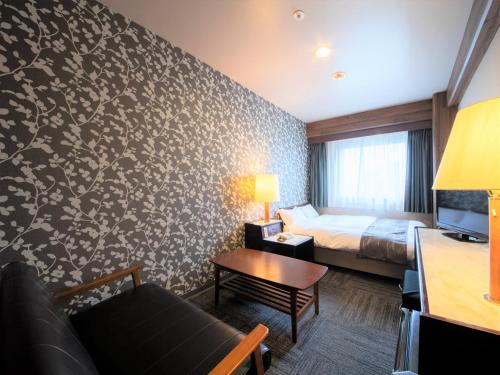 a hotel room with a bed and a couch at Hotel Anesis Seto-Ohashi in Utazu