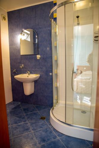 a bathroom with a sink and a glass shower at Bariakov Family Hotel in Bansko
