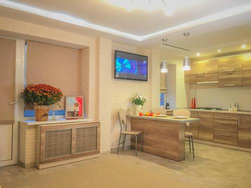 a kitchen with a table and a tv on the wall at Studio Luxe on Victory Street in the city center in Vinnytsya