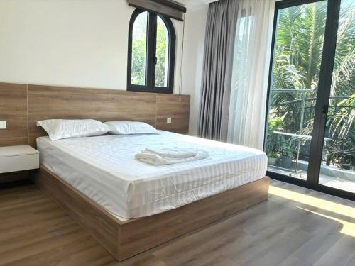 a bedroom with a large bed and a large window at Canisa Villas in Phú Quốc
