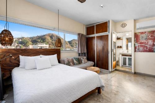 a bedroom with a large bed and a large window at Romantic Zone in Puerto Vallarta