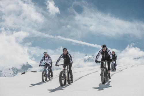 a group of people riding bikes down a snow covered mountain at Alpenclub in Engelberg