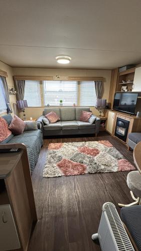 a living room with a couch and a rug at Buckley's Retreat in Chapel Saint Leonards