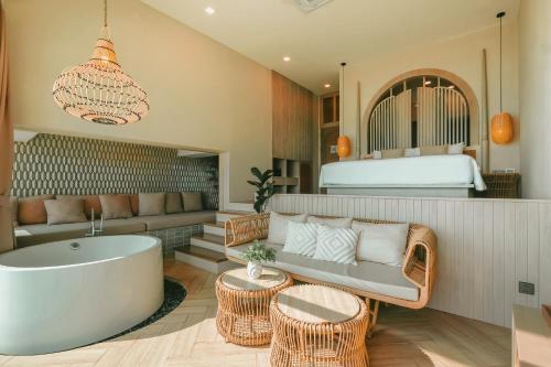 a living room with a tub and a bed at Maldives Beach Resort in Chao Lao Beach