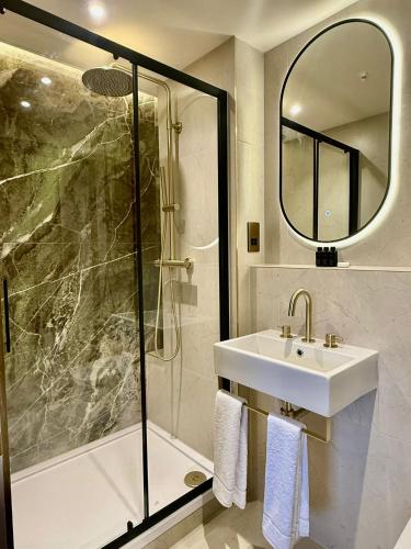 a bathroom with a sink and a shower at The Barkston in London