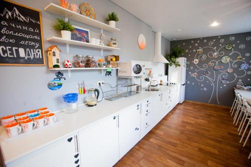a kitchen with white cabinets and a chalkboard on the wall at Geography Hostel Kazan in Kazan