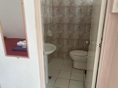 a small bathroom with a toilet and a sink at En Pensionne, Lodging in Iloilo City