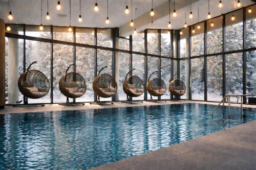 a swimming pool with chairs in front of a large window at Konsum Gästehaus Quisisana - Oberhof in Oberhof