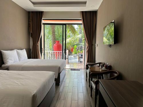 a hotel room with two beds and a table and a window at The Palm Phu Quoc Resort & Villa in Phú Quốc