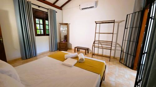 a bedroom with a bed with two towels on it at Villa Mango Serenity in Hikkaduwa