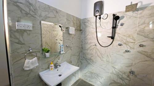 a bathroom with a sink and a shower at Villa Mango Serenity in Hikkaduwa