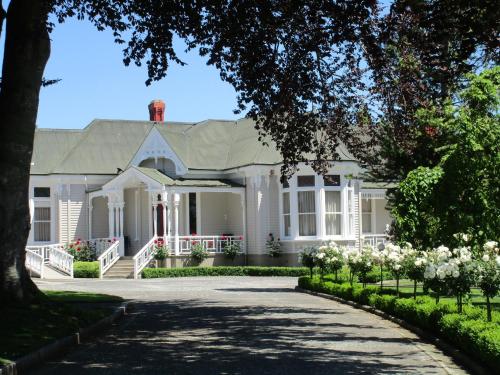 a white house with a driveway at Valmai House & Motel Cambridge in Cambridge