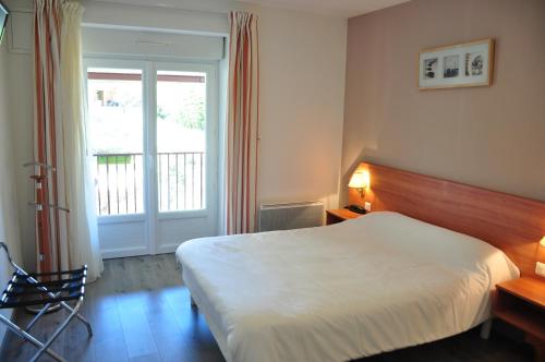 a hotel room with a bed and a window at Logis - Hotel Restaurant du Parc in Cransac