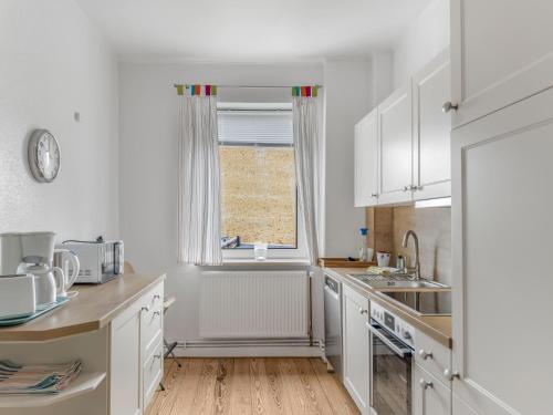 a kitchen with white cabinets and a window at Objekt-Nr 247 - Hafen - Kurgartenstraße in Travemünde
