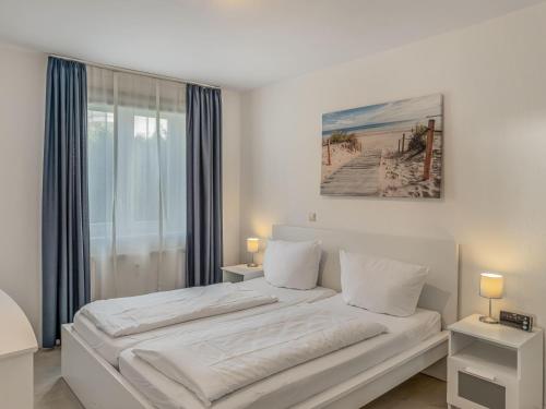 a white bedroom with a large bed and a window at Objekt-Nr 86 - Priwall - Wiekstraße in Priwall