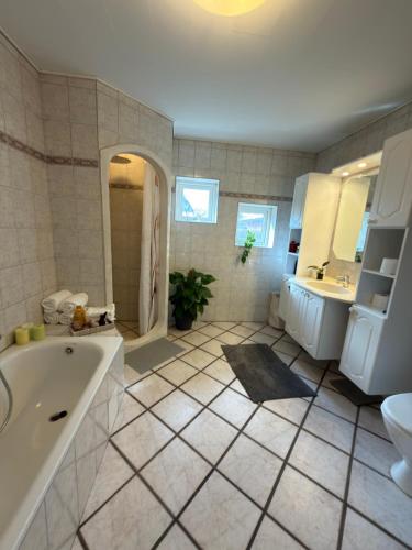 a bathroom with a tub and a toilet and a sink at Sweet Home in Aarhus