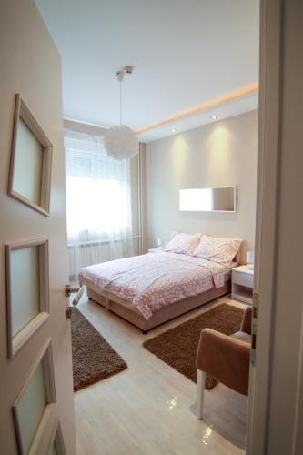 a bedroom with a bed and a chair and a window at Savamala Lux Apartment in Belgrade