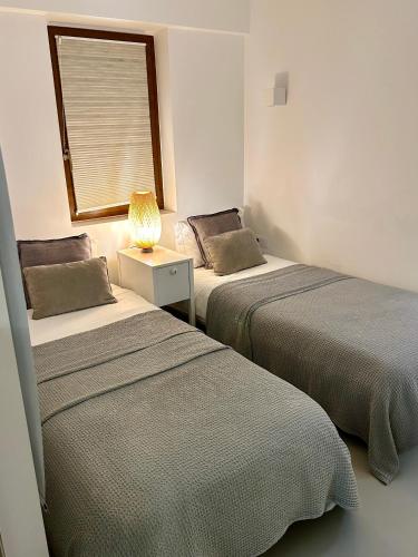 two beds sitting next to each other in a room at Beach House Pedras D'el Rei in Santa Luzia
