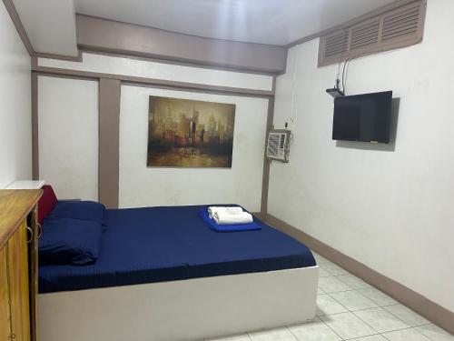 a bedroom with a blue bed in a room at En Pensionne, Lodging in Iloilo City