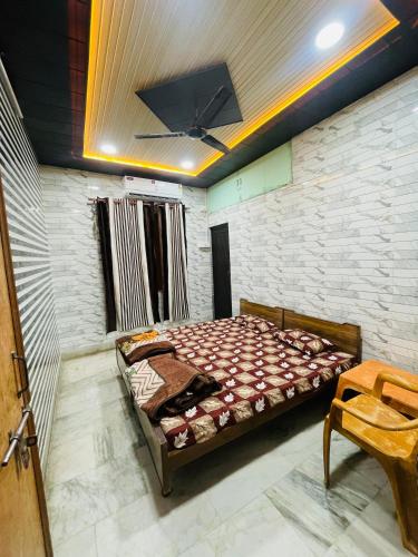 a bedroom with a bed and a stone wall at Dwarkapuri Paras guest house in Mathura