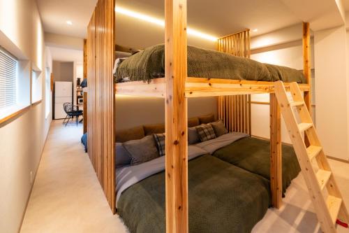 a room with two bunk beds with a ladder at SUNZ ROOMS -naha miebashi- in Naha