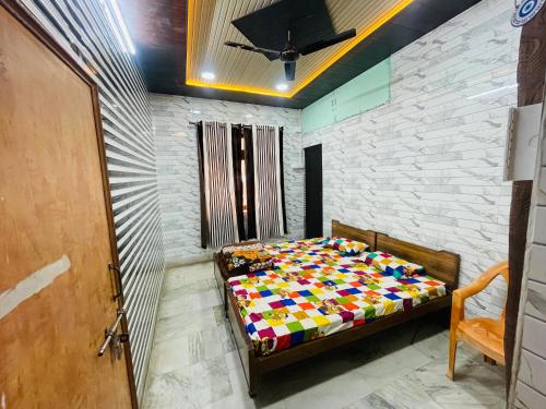 a bedroom with a bed with a colorful comforter at Dwarkapuri Paras guest house in Mathura