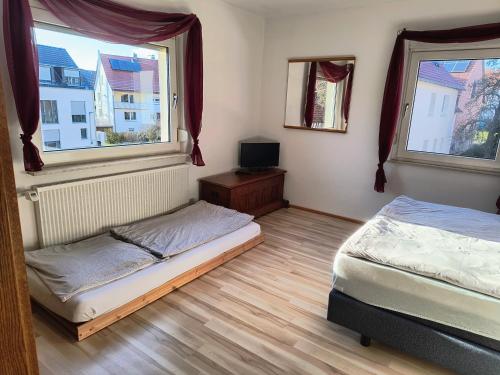two beds in a room with two windows at Haus-Dorfidyll in Spangenberg