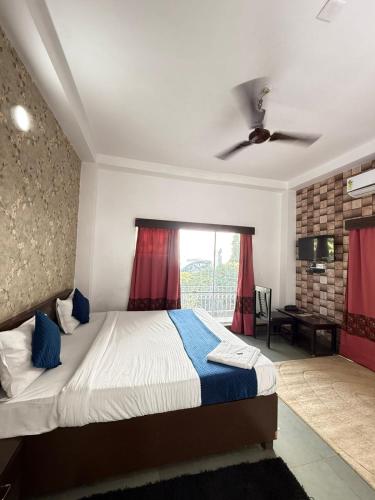 a bedroom with a bed and a ceiling fan at Hotel Arawali Hill in Udaipur