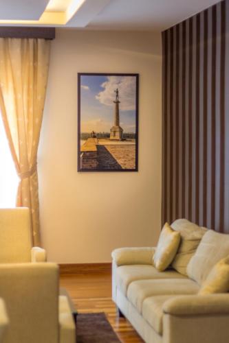a living room with a couch and a picture of a lighthouse at Feel Belgrade Apartments in Belgrade