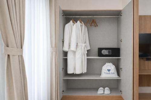 a walk in closet with white towels and a window at Vitash Inn in Tirupati