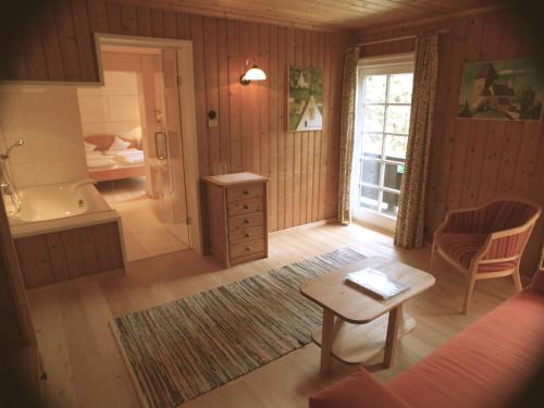 a room with a bathroom with a tub and a table at Biohotel Grafenast in Pill