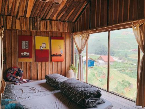 a bed in a room with a large window at Lee Eco House Sapa in Sapa