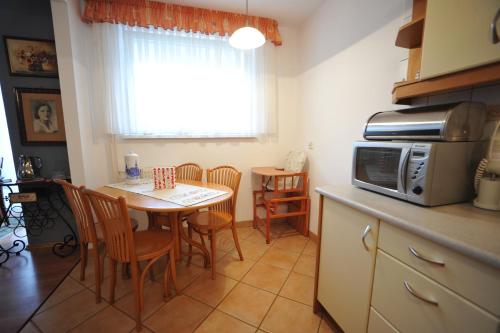 a kitchen with a table with chairs and a microwave at Apartament Tais in Wrocław