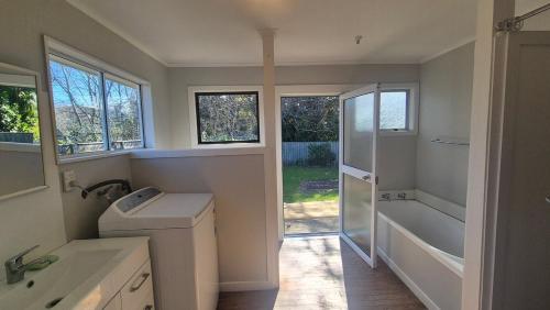 a bathroom with a shower and a toilet and a sink at Bach 30 at Waimārama Beach in Waimarama