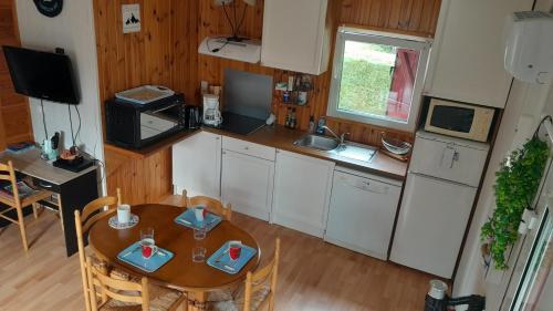 a kitchen with a table and a small table and chairs at Le chalet Paradis in Estang