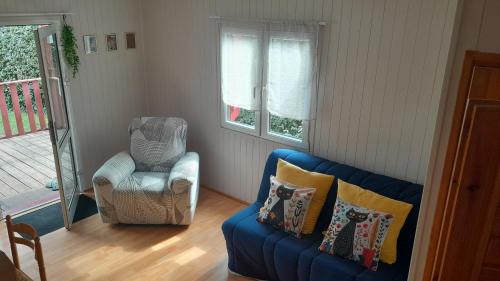 a living room with a blue couch and a chair at Le chalet Paradis in Estang
