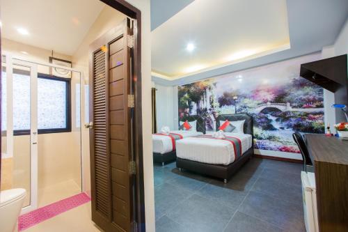 a hotel room with two beds and a bathroom at D11 Hotel in Phitsanulok
