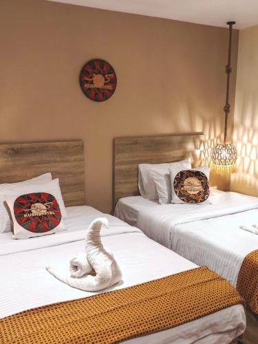 a bedroom with two beds with a towel animal on them at Nubian Hotel in Cairo