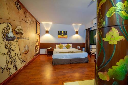 a bedroom with a bed and a wall with a mural at The Ligor City Hotel in Nakhon Si Thammarat