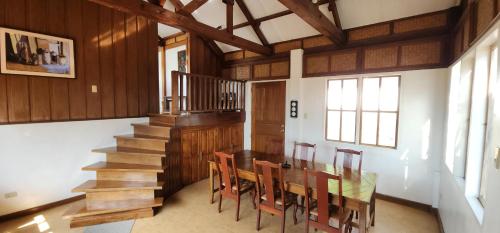 a dining room with a table and chairs and stairs at The Amazing Villa in Anepahan