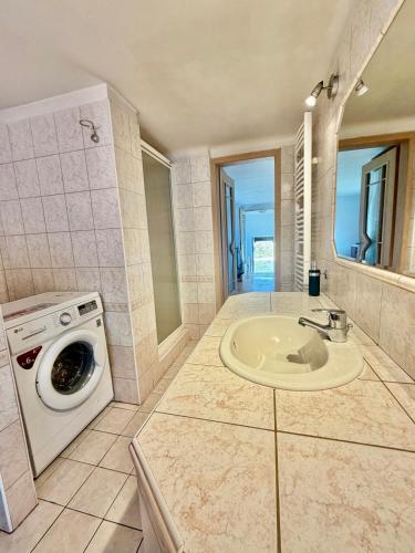 a bathroom with a washing machine and a sink at U potůčku in Ledce