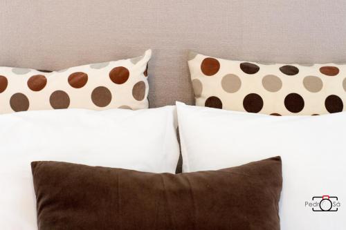 a group of pillows sitting on top of a bed at Marnoto´s City Apartment in Aveiro