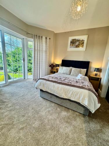 a bedroom with a large bed and a chandelier at Whitaker Lodge in Swinford