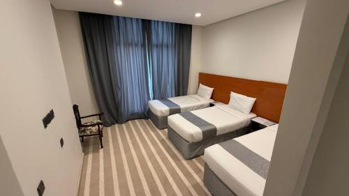 a hotel room with two beds and a couch at فندق العلاء 4 in Al Masfalah