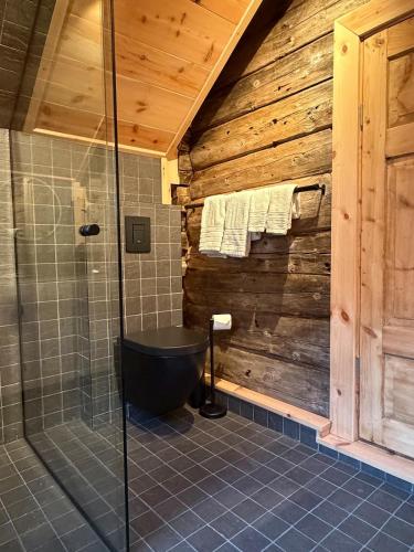 a bathroom with a shower and a black bath tub at Urastova in Vassenden