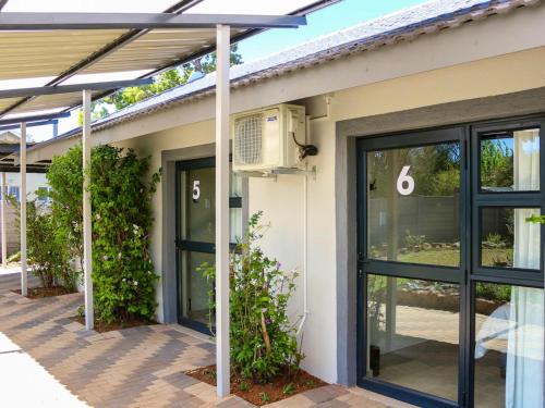 a building with glass doors and a fan at Wild Olive Luxury Accommodation in Newcastle