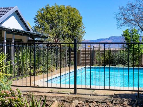 a fence around a swimming pool in a house at Wild Olive Luxury Accommodation in Newcastle